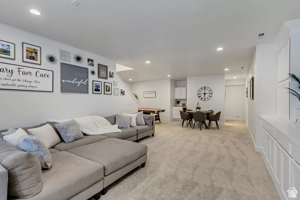 Living room featuring light carpet, recessed lighting, stairs, and baseboards