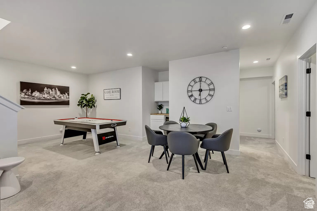 Dining area with light colored carpet, baseboards, and recessed lighting