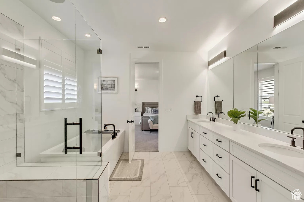 Bathroom with marble finish flooring, ensuite bathroom, double vanity, a shower stall, and recessed lighting
