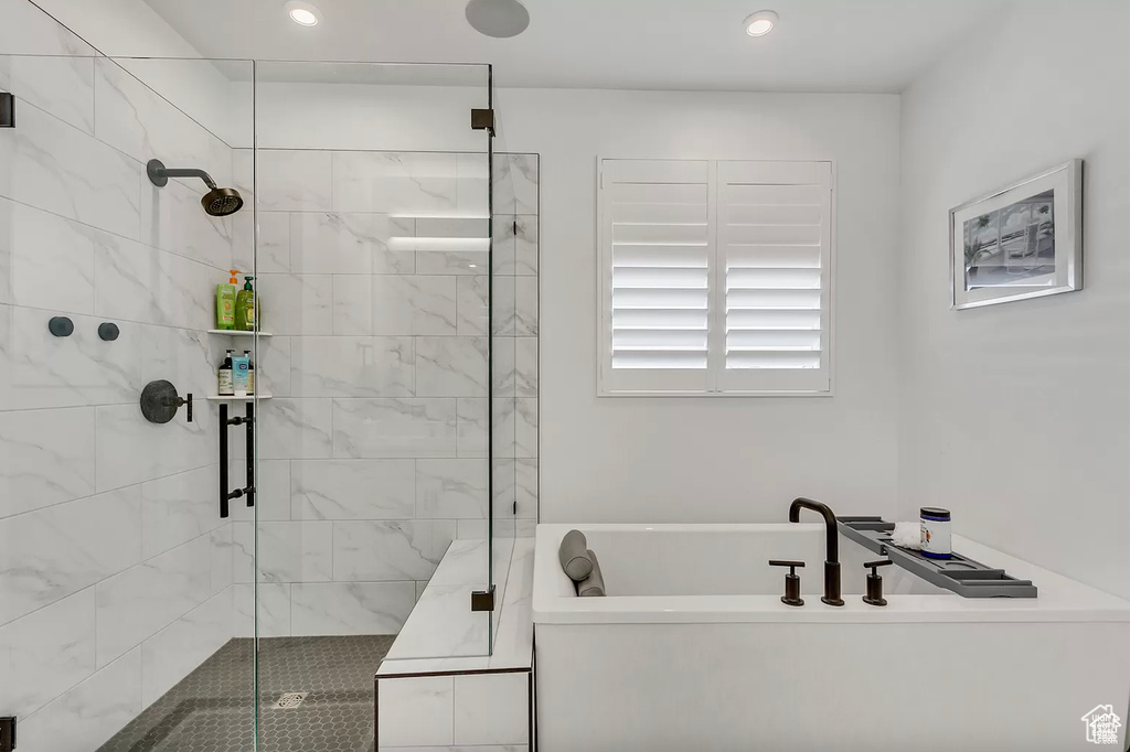 Bathroom featuring a soaking tub, a shower stall, and recessed lighting