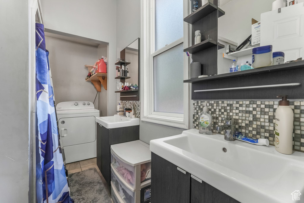 Full bathroom featuring washer / clothes dryer, decorative backsplash, tile patterned flooring, and vanity
