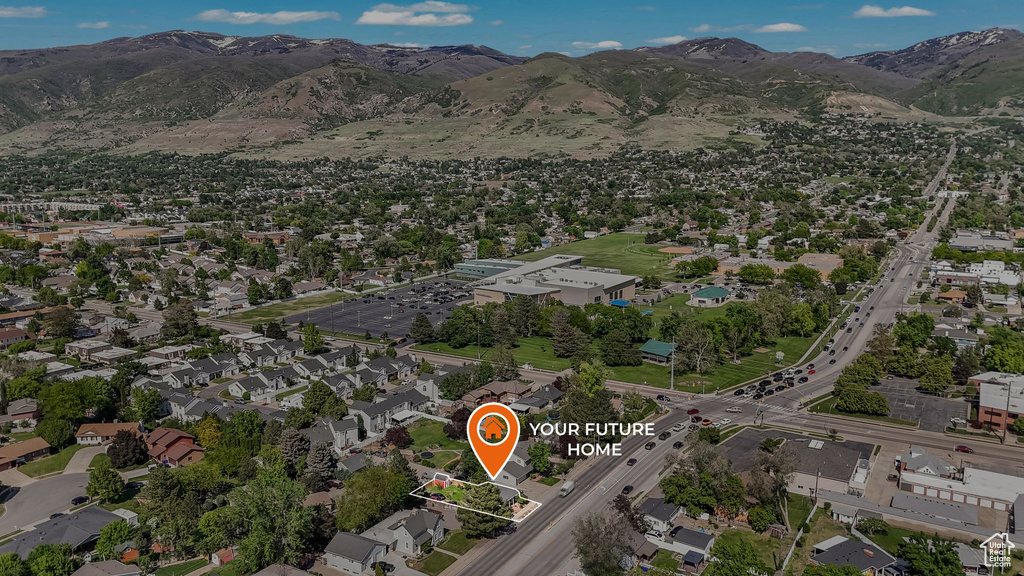 Aerial overview of property's location featuring a mountainous background and nearby suburban area
