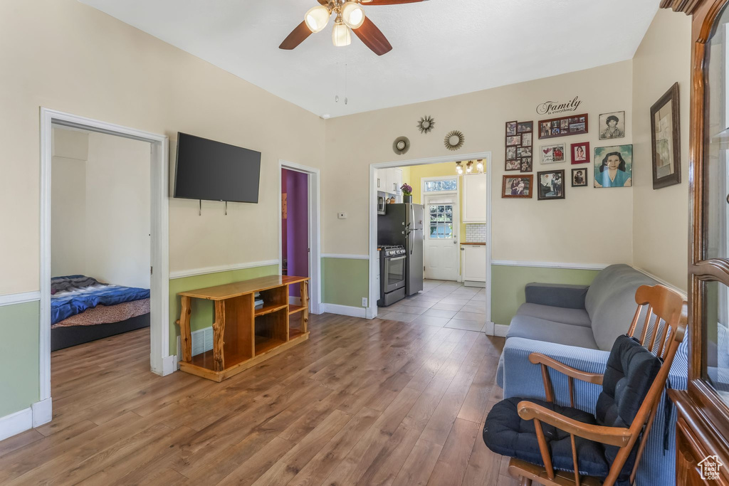 Sitting room featuring ceiling fan, wood finished floors, and baseboards