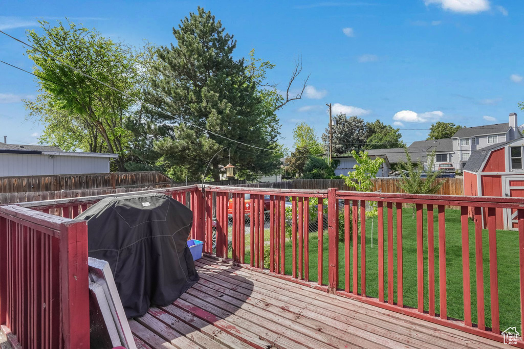 Deck featuring a storage shed and an outbuilding