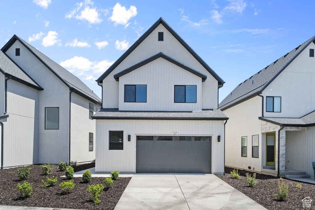 Modern farmhouse style home featuring driveway and an attached garage