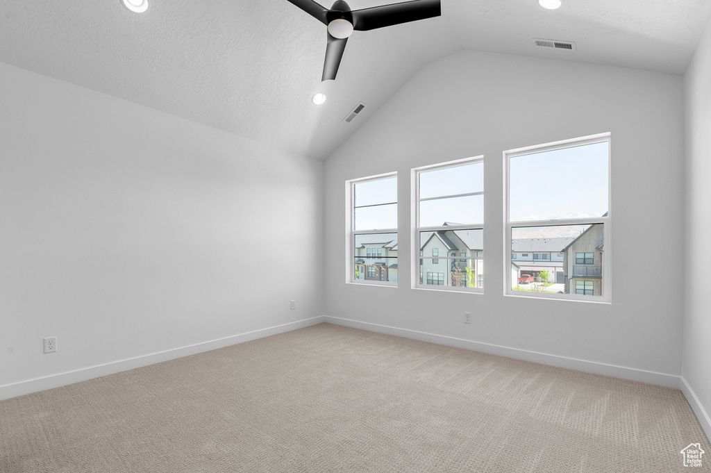 Spare room featuring a ceiling fan, lofted ceiling, recessed lighting, light carpet, and baseboards