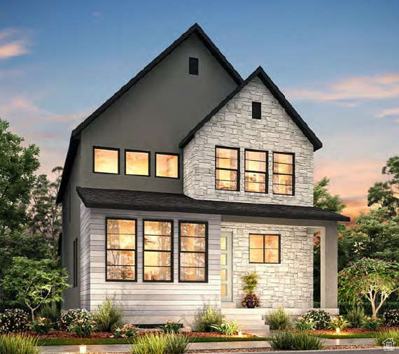 Back of property at dusk with stone siding