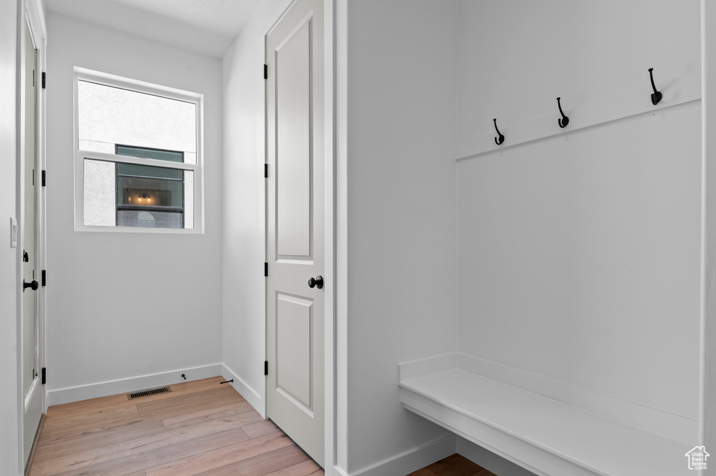 Mudroom with light wood-style flooring and baseboards