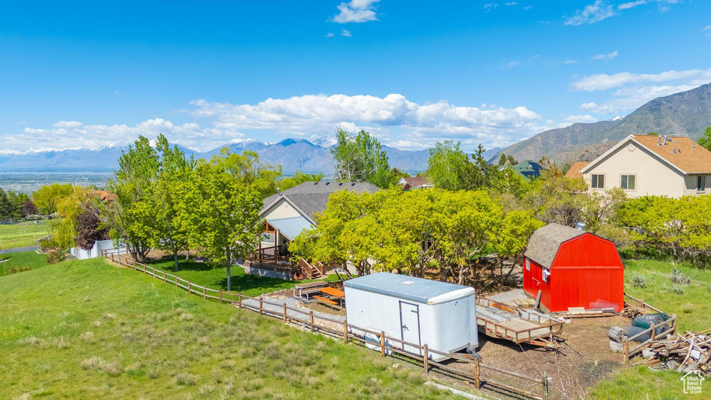 View of yard featuring a storage unit, an outdoor structure, and a mountain view