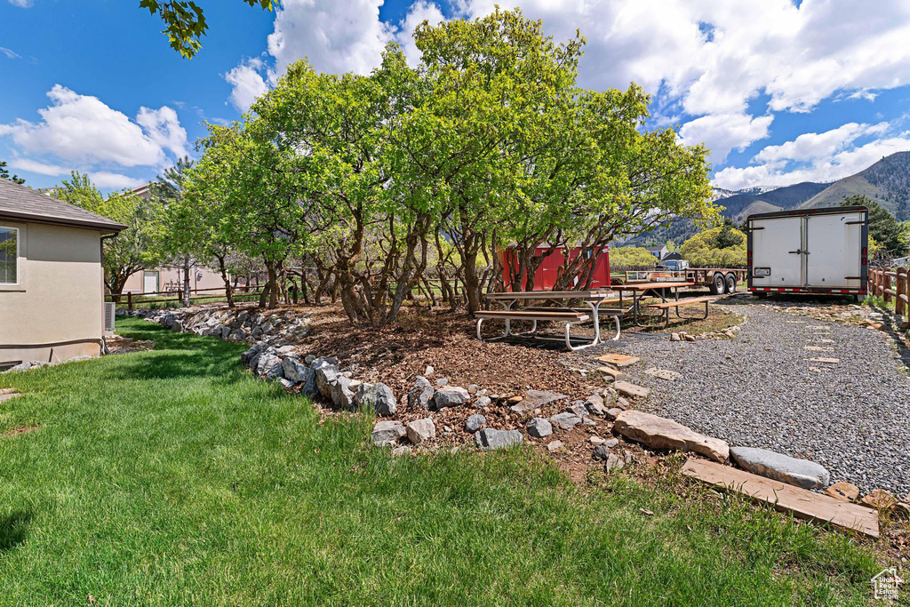 View of yard featuring a mountain view, a storage shed, and an outdoor structure