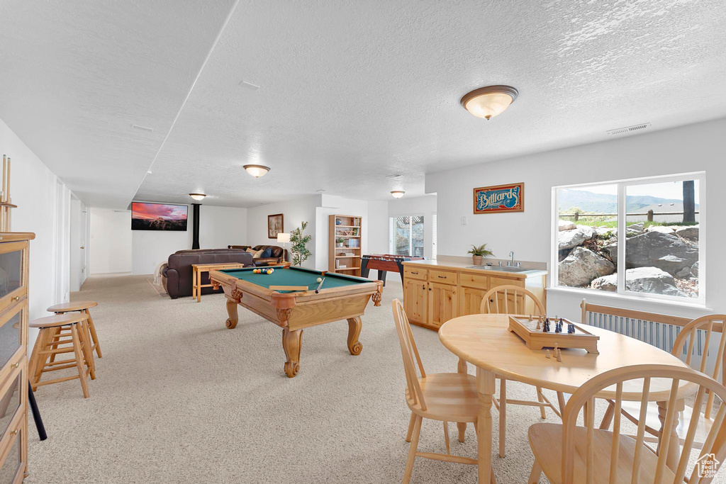 Game room featuring pool table, a textured ceiling, a sink, and light colored carpet