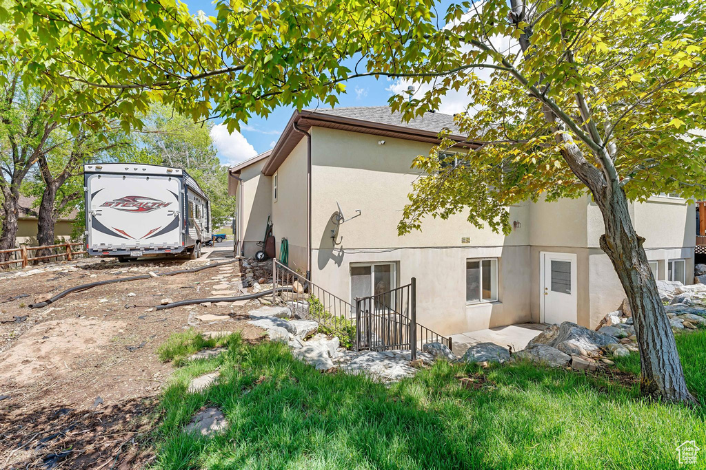 Rear view of property featuring stucco siding and fence