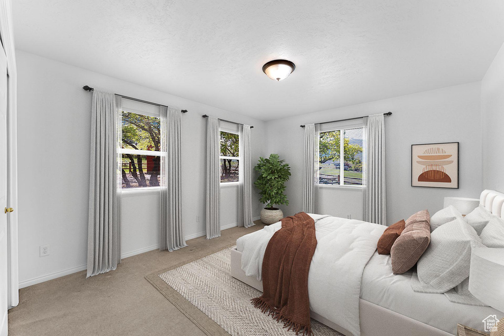 Bedroom featuring light colored carpet and baseboards