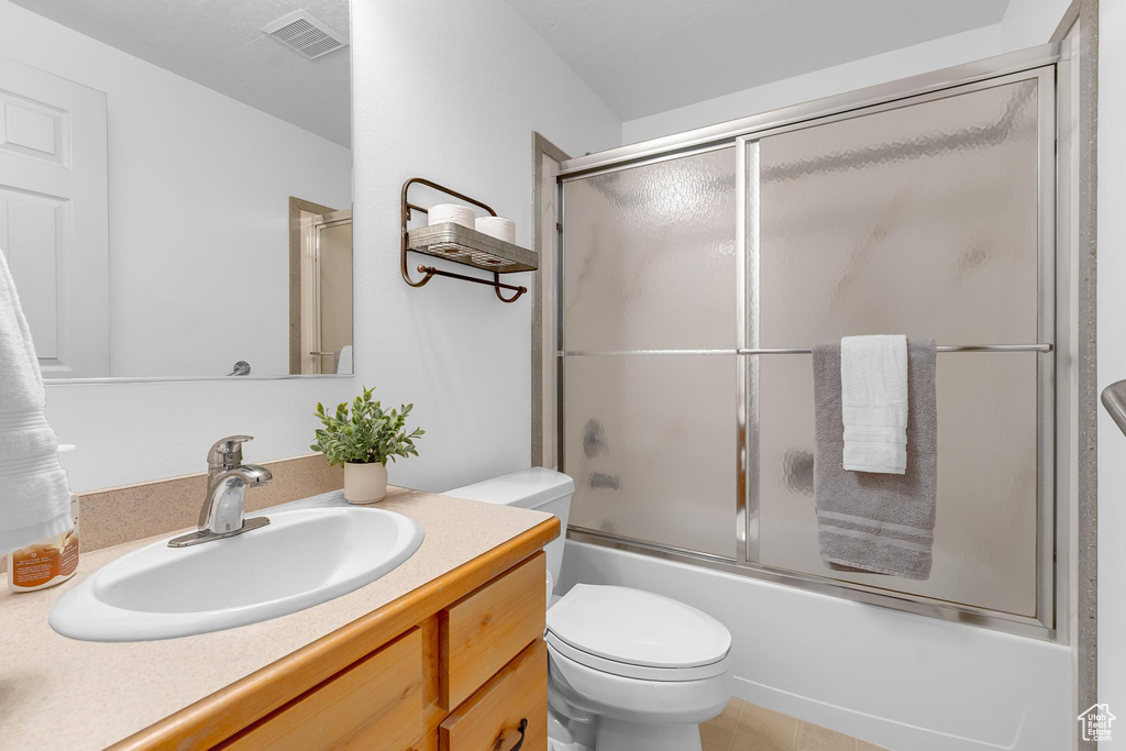Full bath with toilet, shower / bath combination with glass door, and vanity