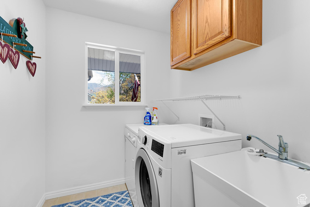 Laundry area with washer and dryer, cabinet space, and baseboards
