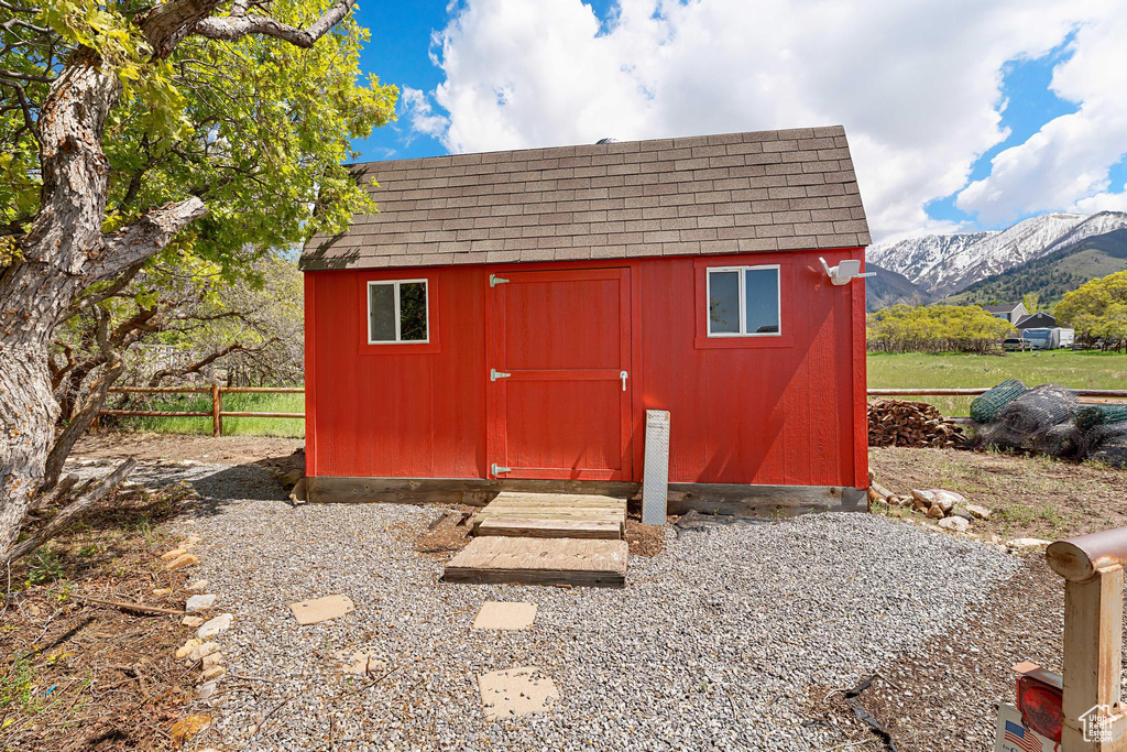 View of shed with a mountain view and fence