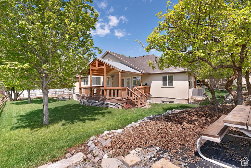 Rear view of property featuring a wooden deck and stucco siding