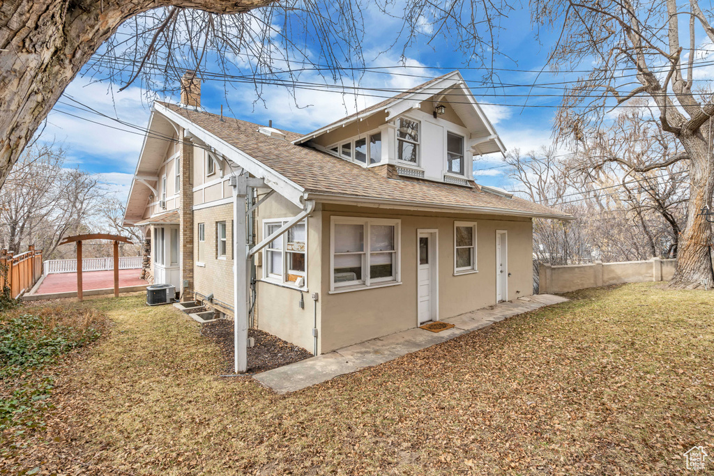 View of property exterior with a shingled roof, a chimney, central AC, and stucco siding