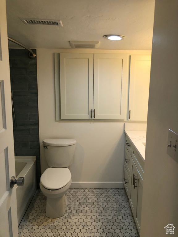 Bathroom with tile patterned flooring, vanity, toilet, baseboards, and shower / bathtub combination