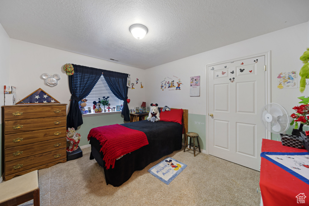 Bedroom featuring a textured ceiling, carpet, and baseboards