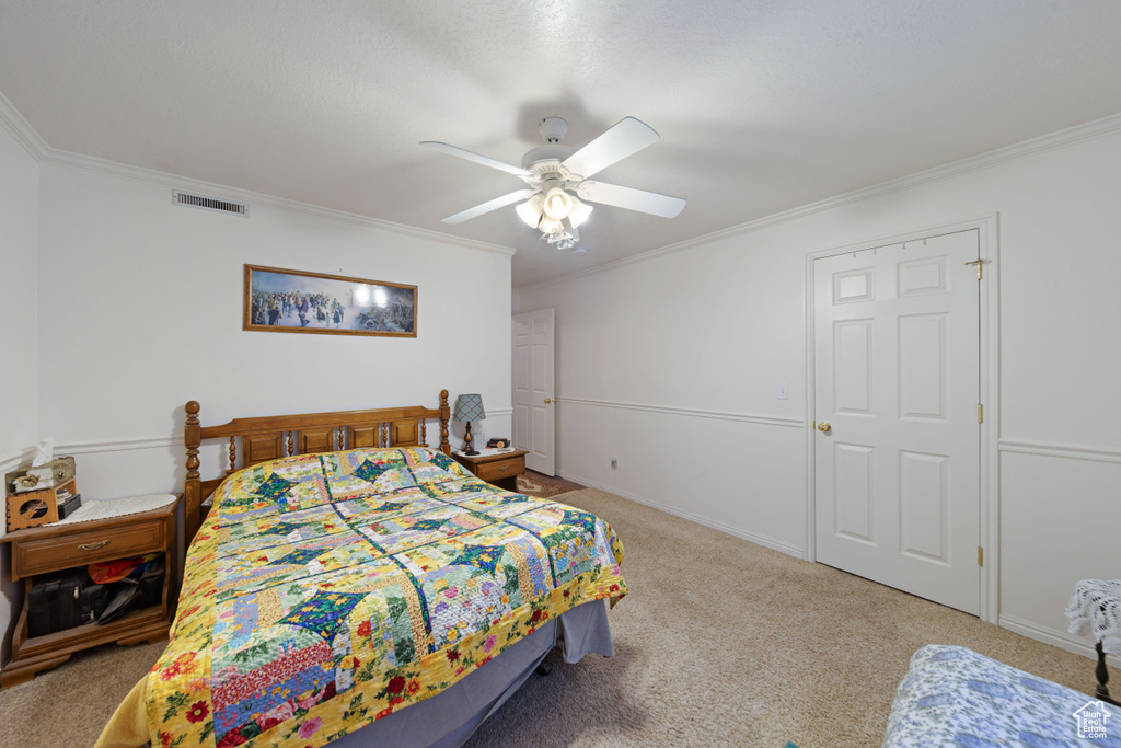 Bedroom featuring ornamental molding, carpet flooring, and ceiling fan