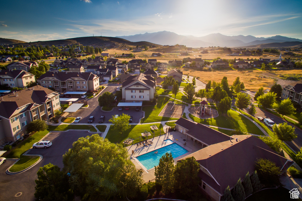 Aerial view of residential area featuring a mountainous background and a pool area