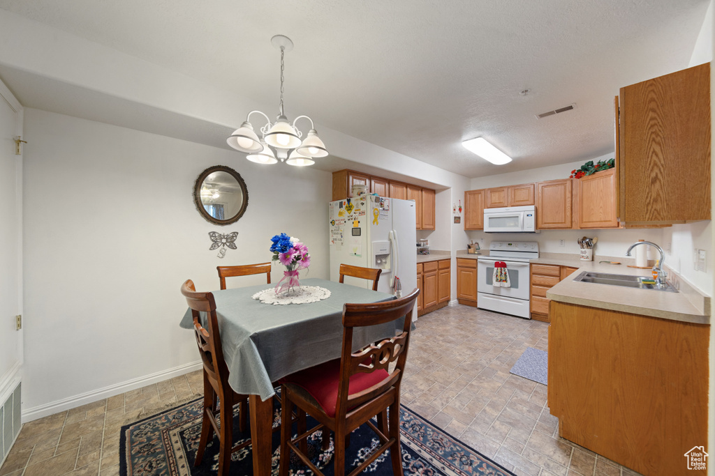 Dining space with stone finish flooring, a chandelier, and baseboards