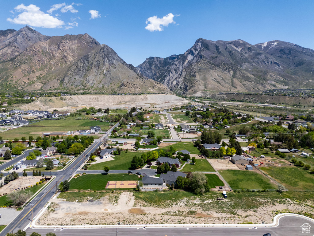Aerial view of property and surrounding area featuring a mountain backdrop and nearby suburban area