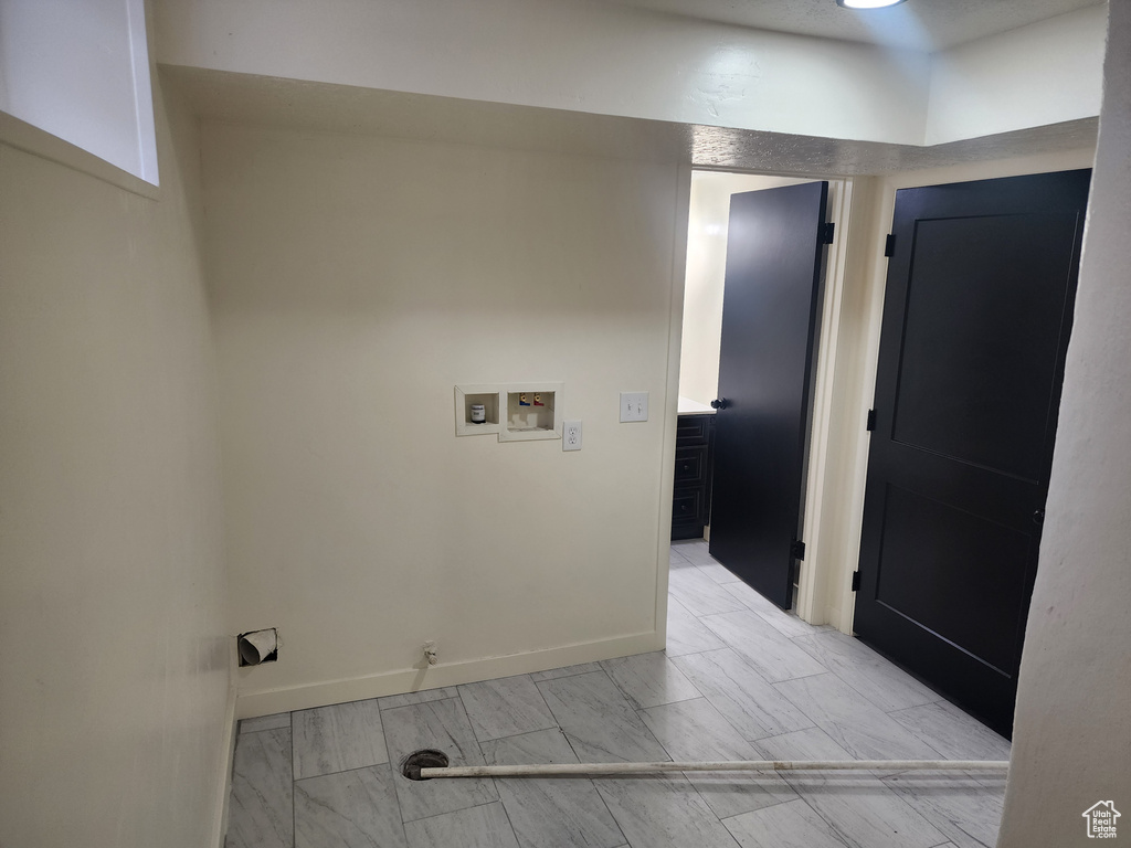 Clothes washing area featuring washer hookup and baseboards