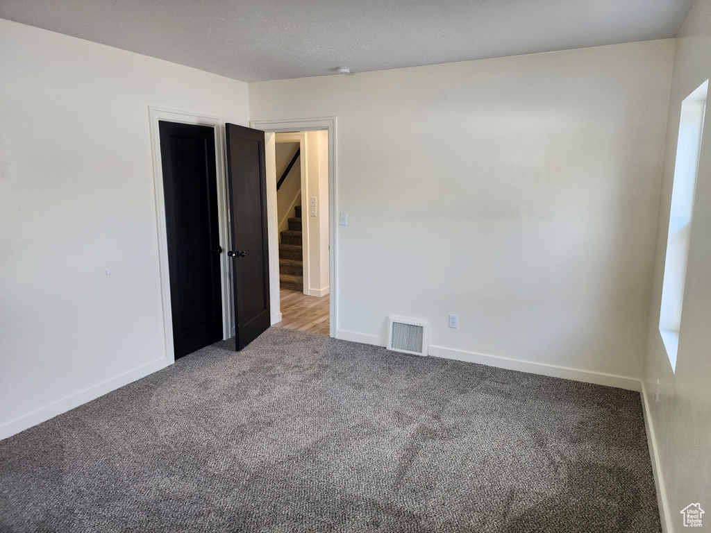 Empty room featuring carpet floors and baseboards