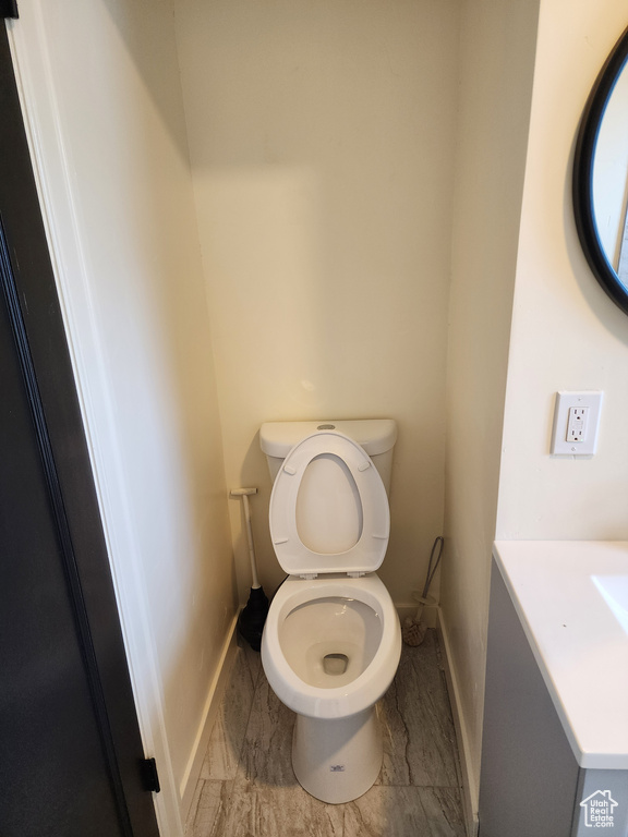 Bathroom with baseboards, toilet, and vanity
