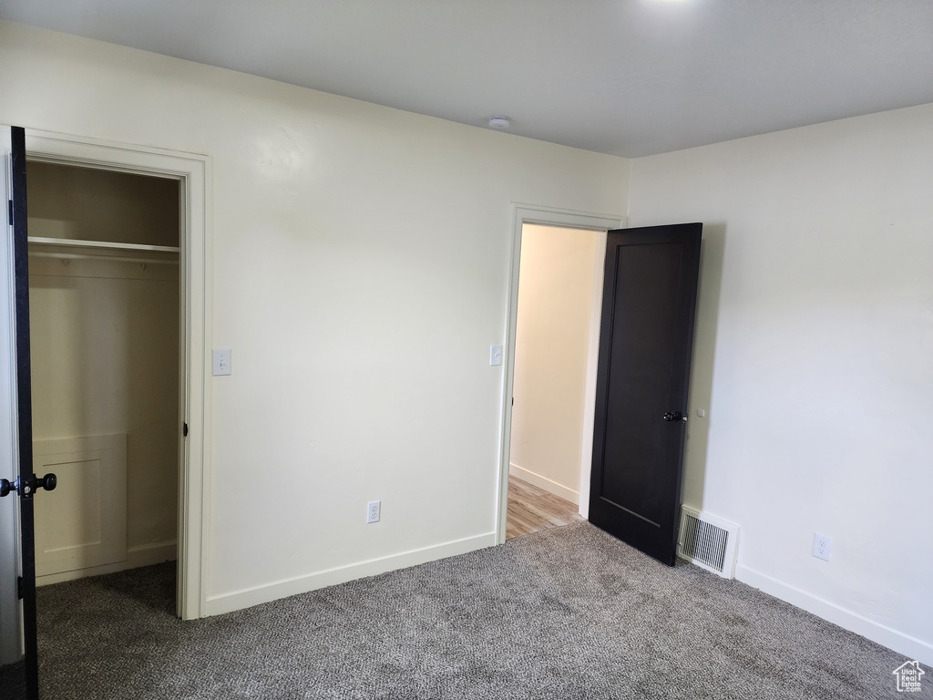 Unfurnished bedroom with carpet floors, baseboards, and a closet
