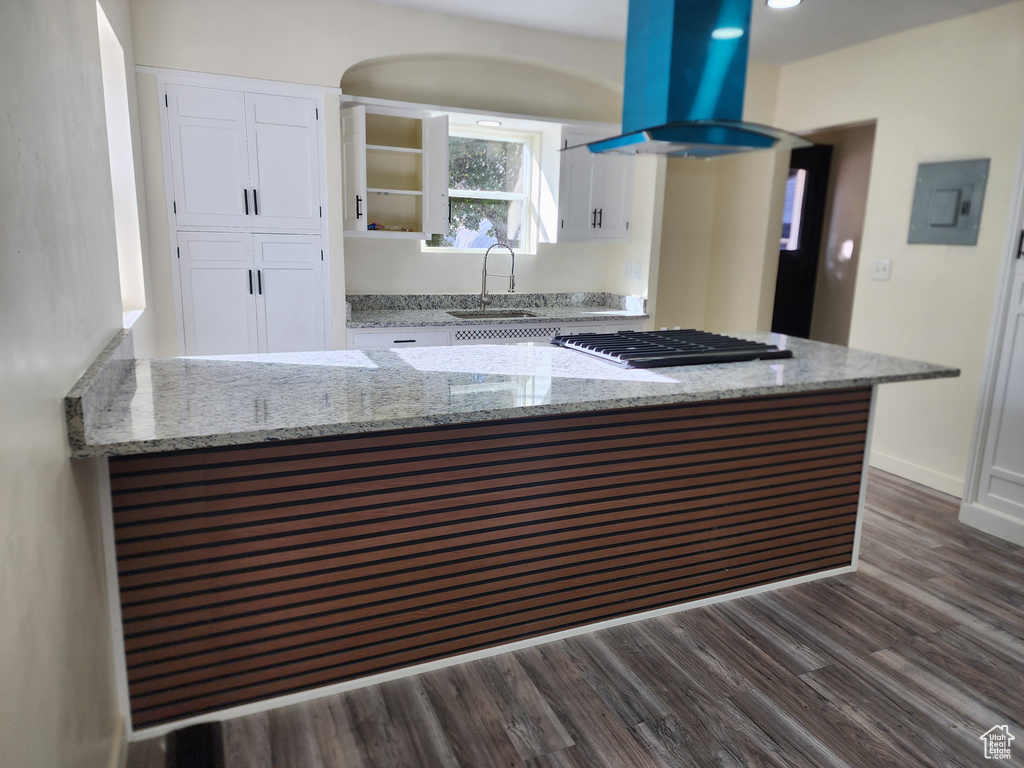 Kitchen with stainless steel gas cooktop, a sink, island exhaust hood, white cabinetry, and dark wood-style flooring