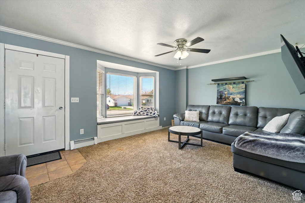 Living room with a baseboard heating unit, ceiling fan, ornamental molding, a textured ceiling, and tile patterned floors