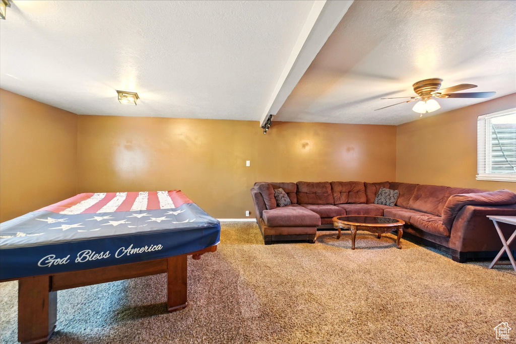 Recreation room featuring carpet, a ceiling fan, baseboards, and a textured ceiling