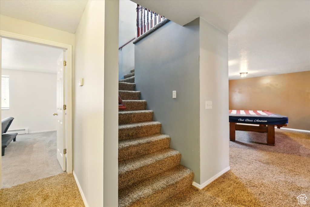 Stairs featuring carpet floors, baseboards, and a baseboard radiator