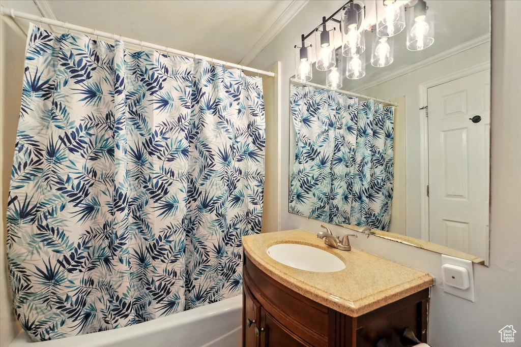 Bathroom featuring ornamental molding, vanity, and shower / tub combo