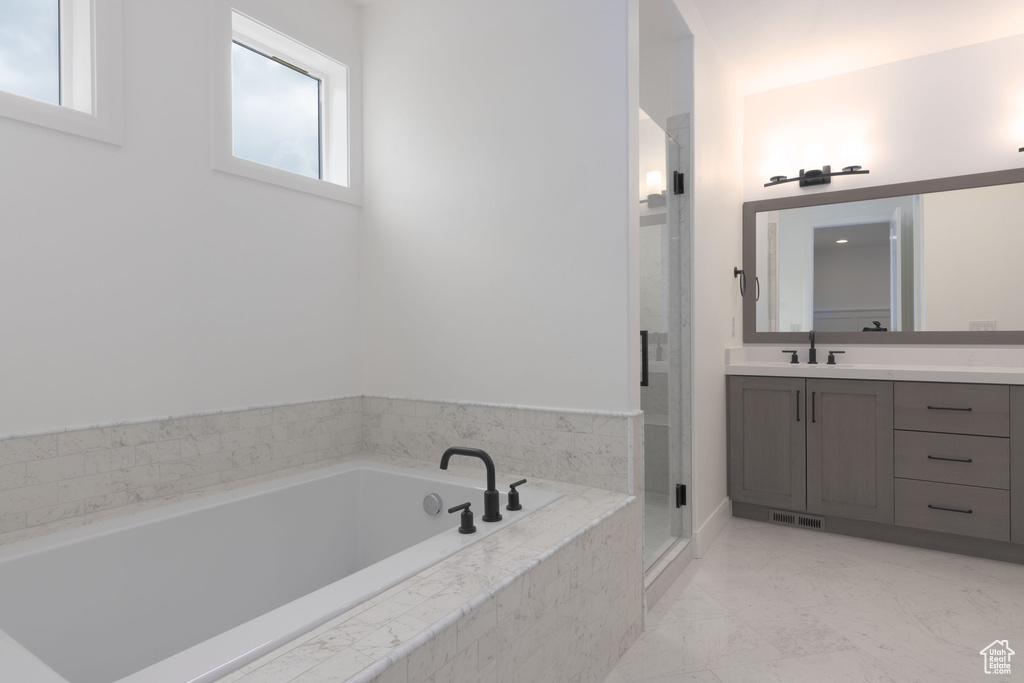 Bathroom featuring vanity, a stall shower, and a garden tub