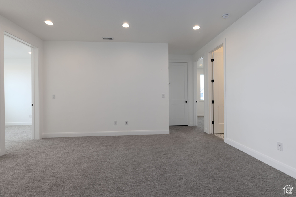 Carpeted spare room with recessed lighting and baseboards