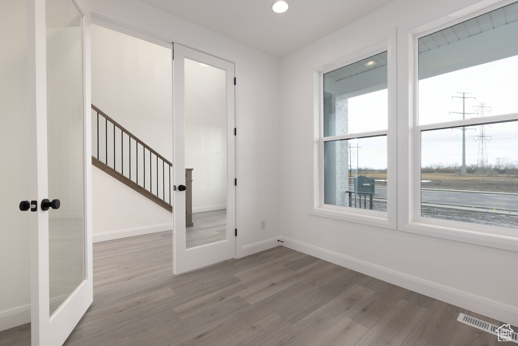 Entrance foyer with wood finished floors, baseboards, recessed lighting, and french doors
