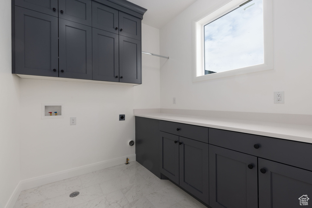 Laundry room featuring washer hookup, light marble finish floors, baseboards, cabinet space, and hookup for an electric dryer