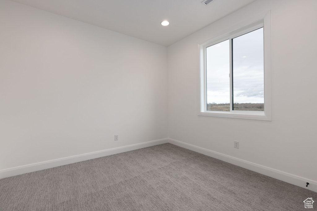 Empty room with baseboards, light carpet, and recessed lighting