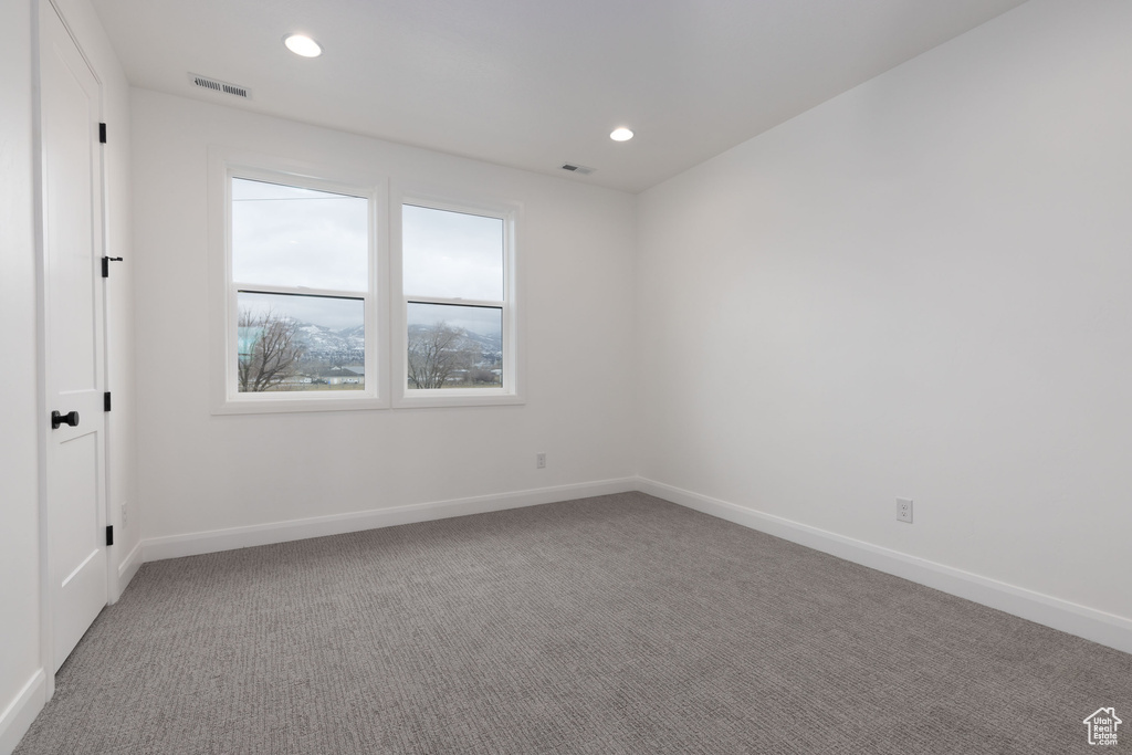 Carpeted spare room featuring baseboards and recessed lighting