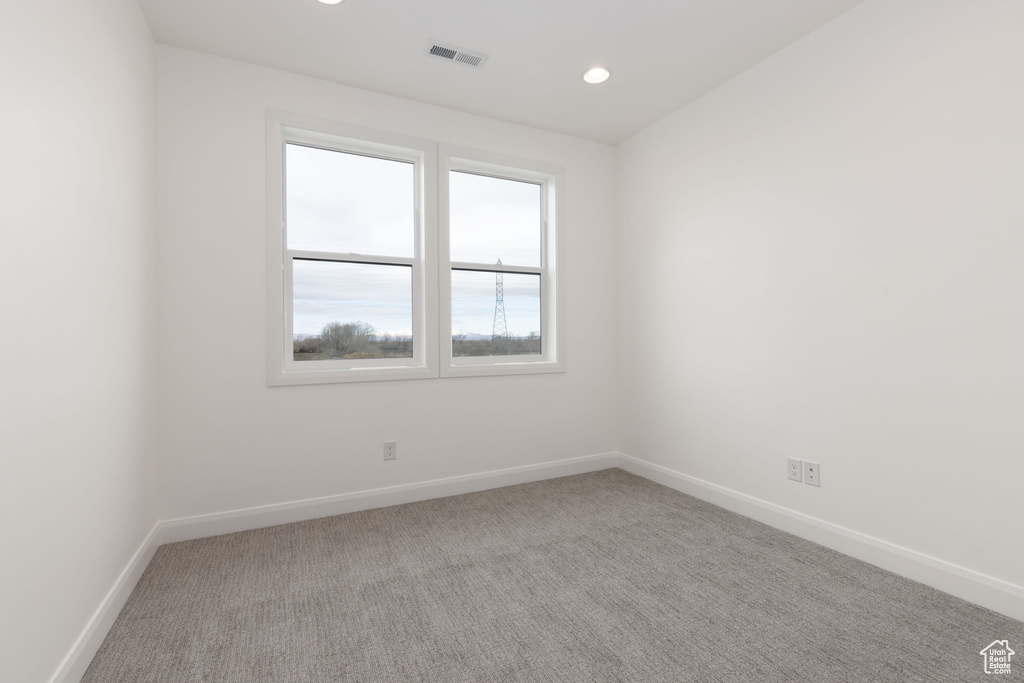 Carpeted empty room featuring baseboards and recessed lighting