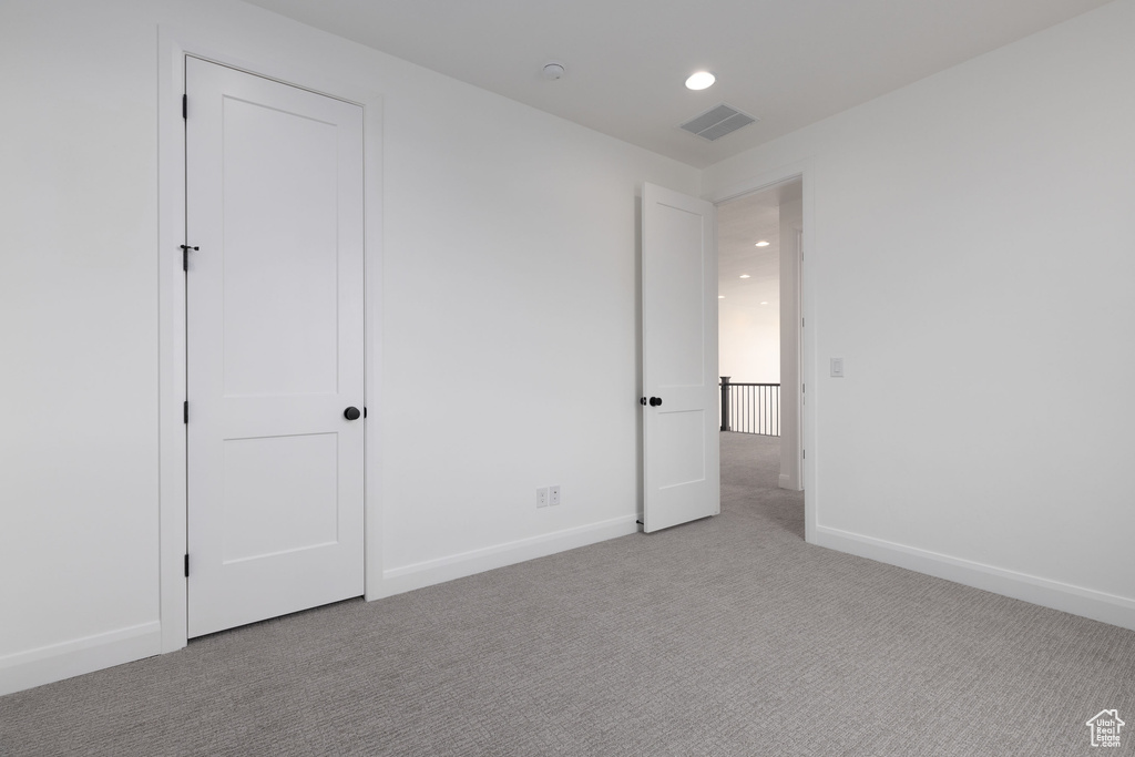 Unfurnished bedroom featuring carpet floors, baseboards, and recessed lighting