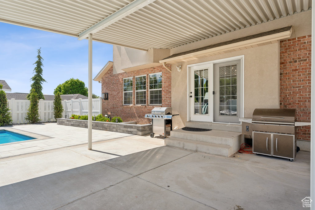 View of patio featuring fence, grilling area, and entry steps
