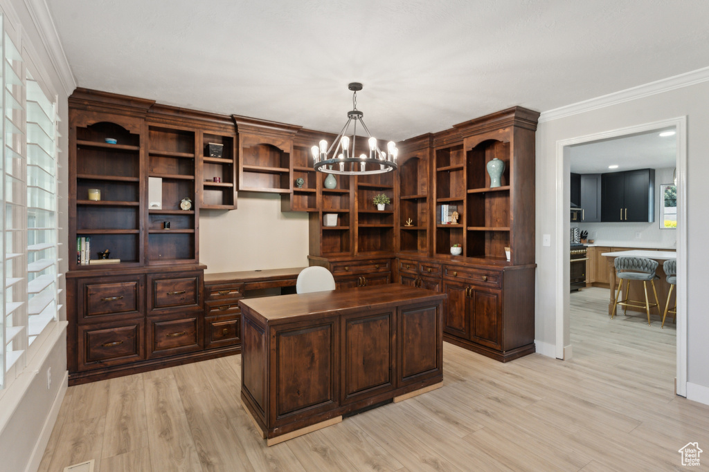 Office space featuring a chandelier, crown molding, light wood finished floors, built in study area, and baseboards