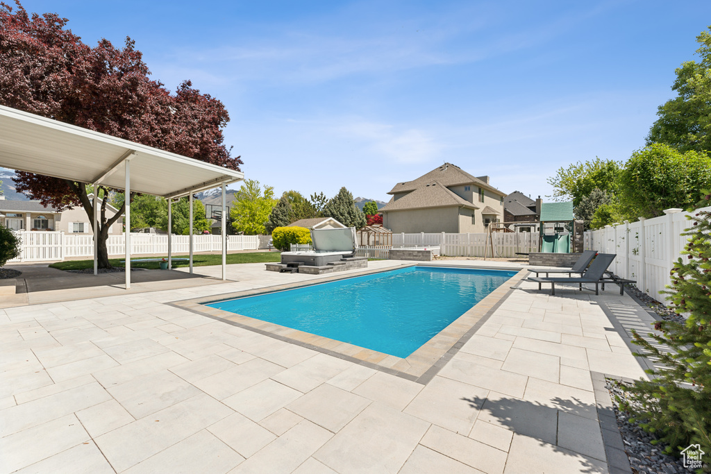 View of pool with a patio, a fenced backyard, and a residential view
