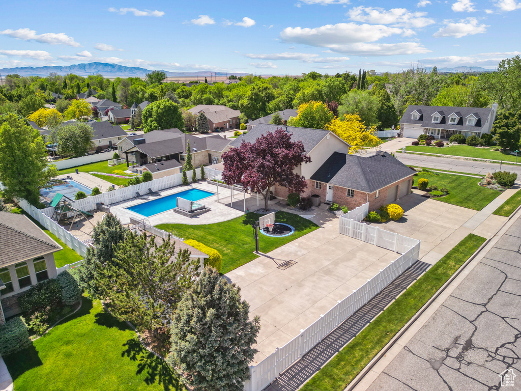 Aerial perspective of suburban area featuring a pool and mountains