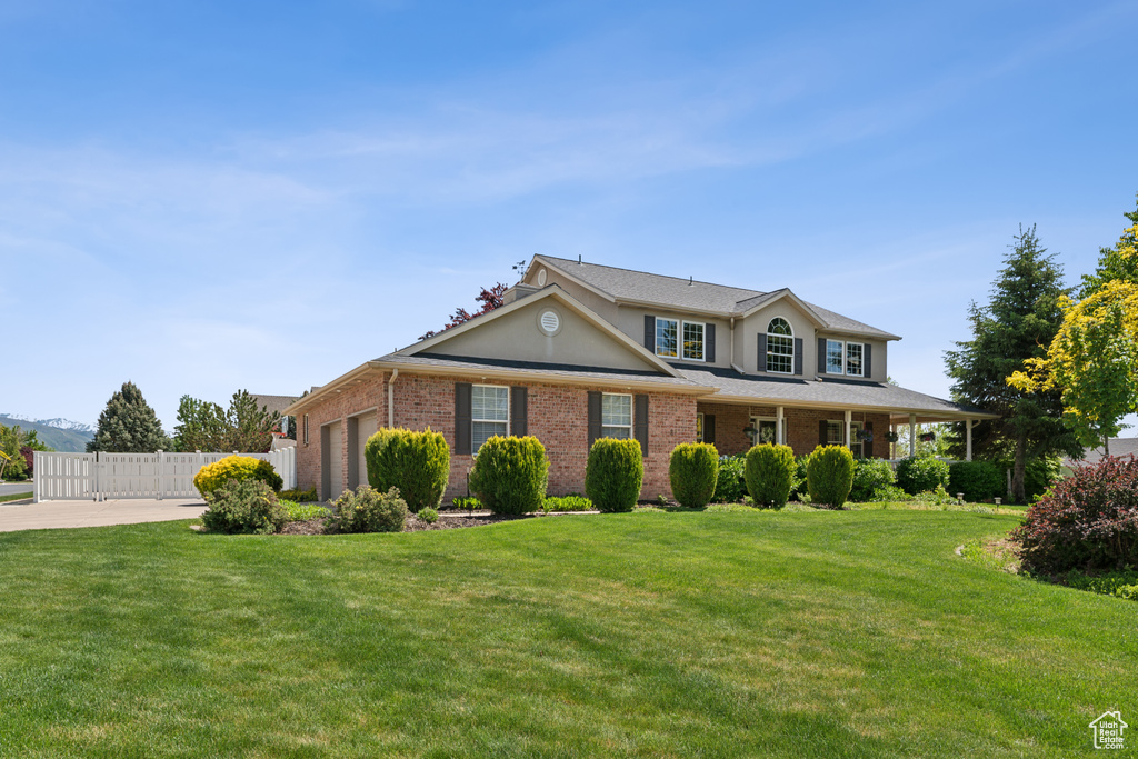 Traditional-style house with a garage, brick siding, and stucco siding